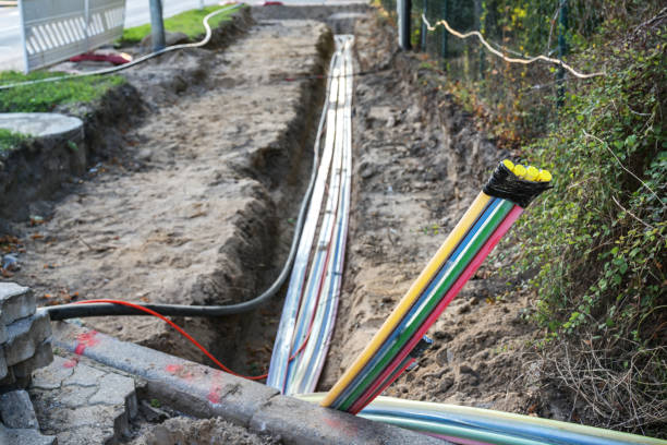 Construction site for installing fiber optic cables under the ground beside a street to bring fast internet to all residents, selected focus, narrow depth of field