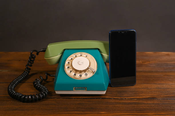 an old wired phone and a modern smartphone an old wired phone and a modern smartphone
