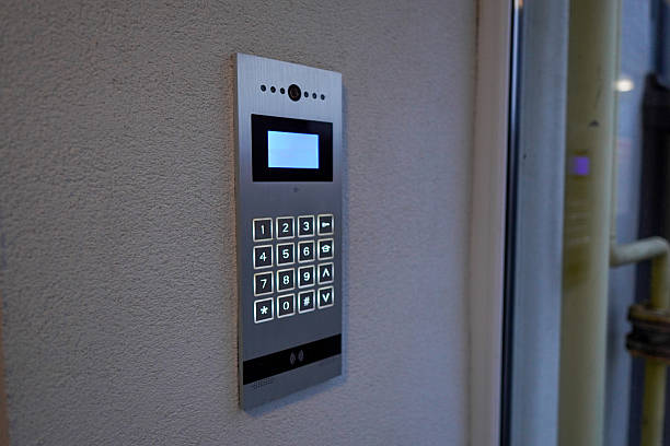 A door entry system with a keypad is mounted on a wall near the entrance. Users can enter numbers to gain access to the building or area.