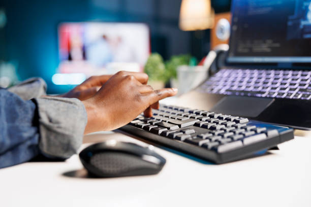 Detailed view of african american pair of hands on keyboard, typing coding information for creating database. Close up of black person inputting data into laptop for online programming.